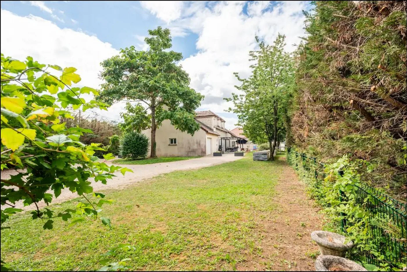 Vue extérieure de la villa en pierre claire avec jardin et pelouse