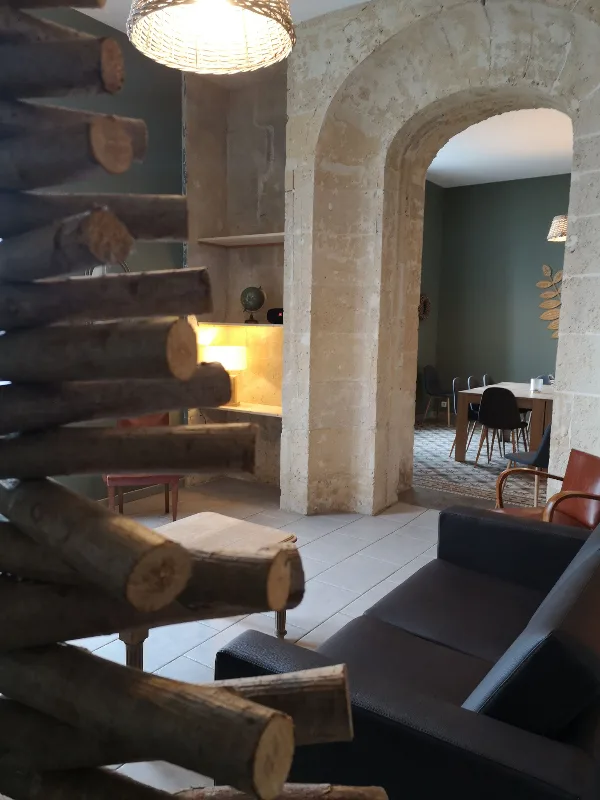 Salon voûté en pierre avec canapé et vue sur la salle à manger