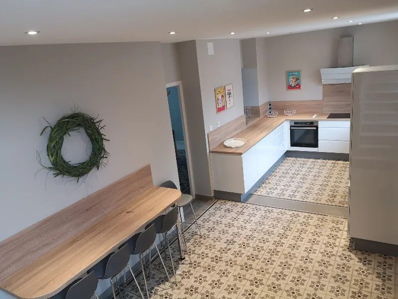 Cuisine ouverte équipée avec bar en bois et carrelage à motifs
