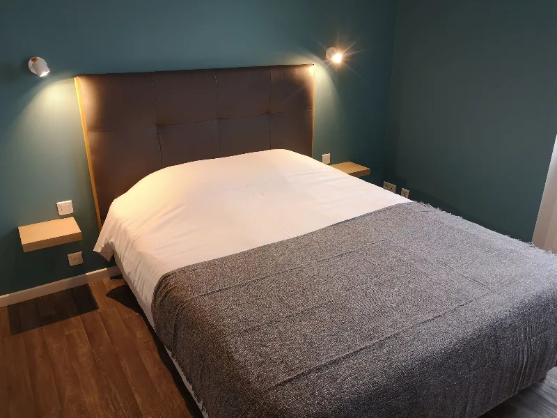 Chambre double avec tête de lit capitonnée et ambiance chaleureuse