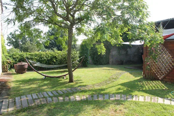 Jardin arboré avec hamac suspendu entre les arbres et coin détente ombragé