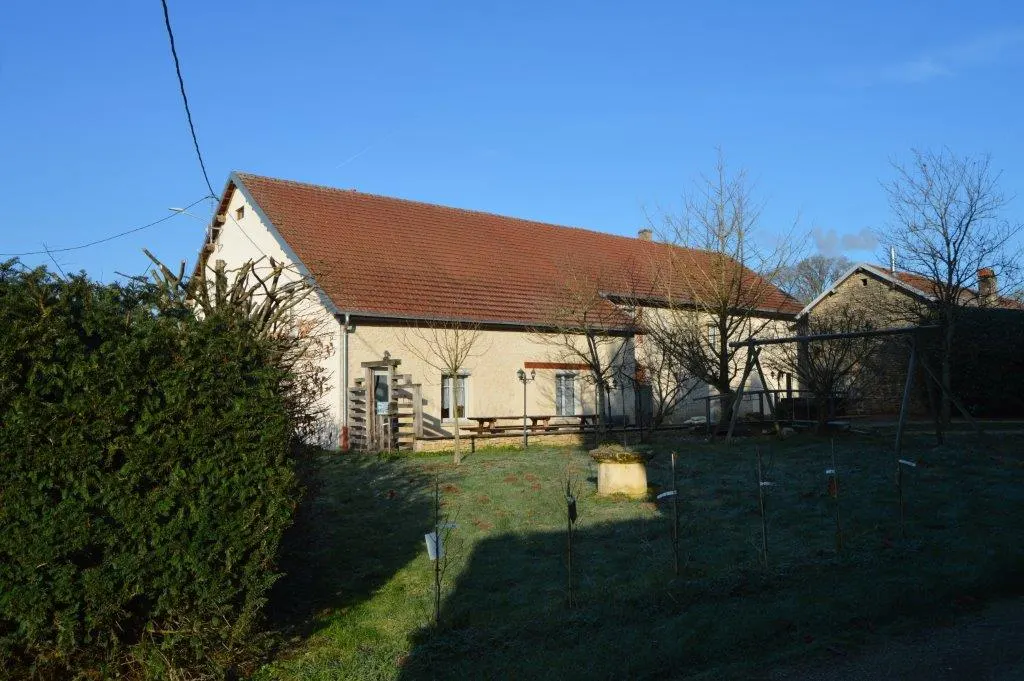 Gîte de groupe Gîte des Amis à Beaumotte-Aubertans — Façade en pierre de la ferme comtoise du Gîte des Amis entourée d'un grand jardin, capacité 14 personnes