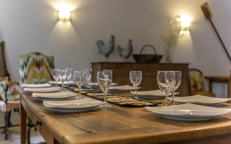 Grande table dressée pour un repas de groupe avec verres à vin et vaisselle blanche