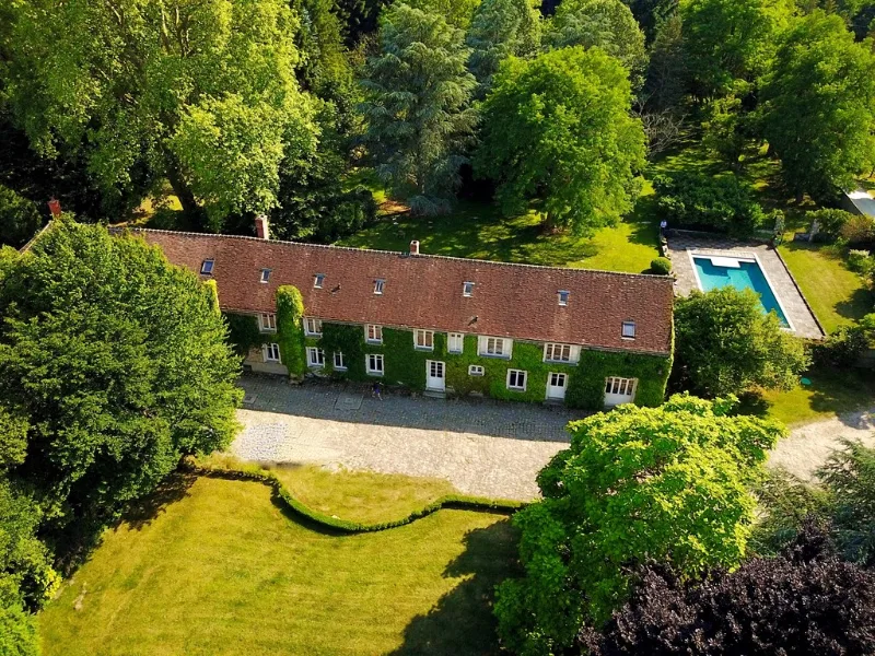 Vue aérienne de la longère en pierre entourée d'arbres centenaires et de son parc