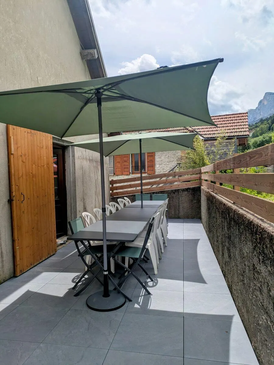 Terrasse extérieure avec salon de jardin et vue sur la montagne
