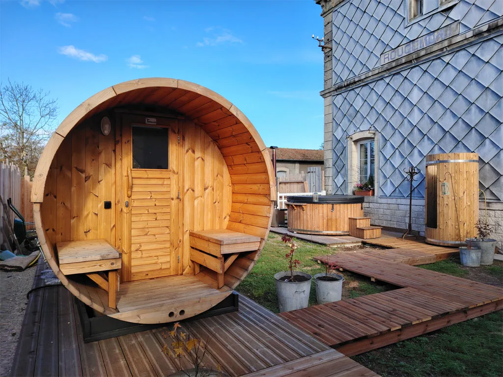 Sauna tonneau chauffé au bois et bain nordique extérieur sur la terrasse en bois