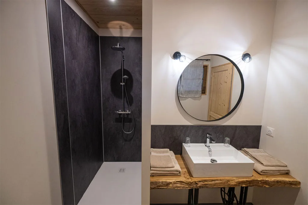 Salle d'eau avec douche à l'italienne et vasque sur plan bois brut