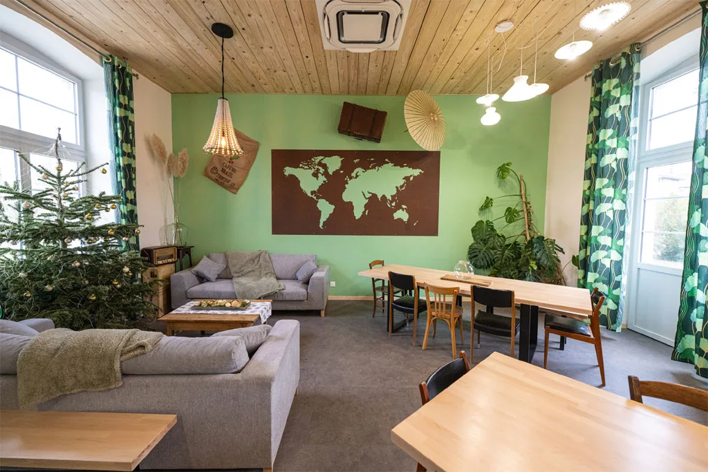 Grande pièce à vivre avec bar, canapés et grandes tables pour les repas de groupe