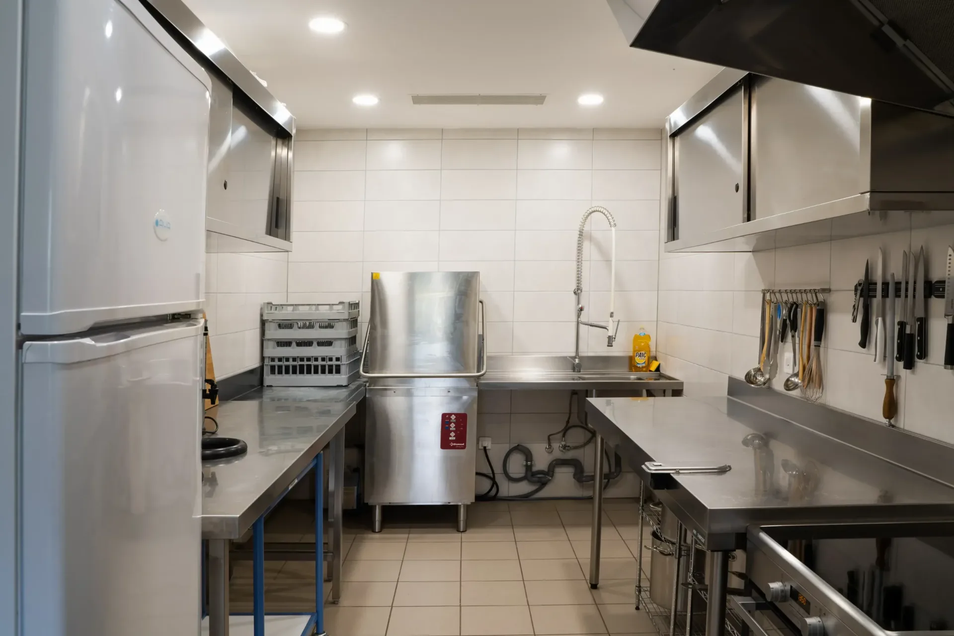 Cuisine semi-professionnelle avec plan de travail inox, lave-vaisselle et hotte