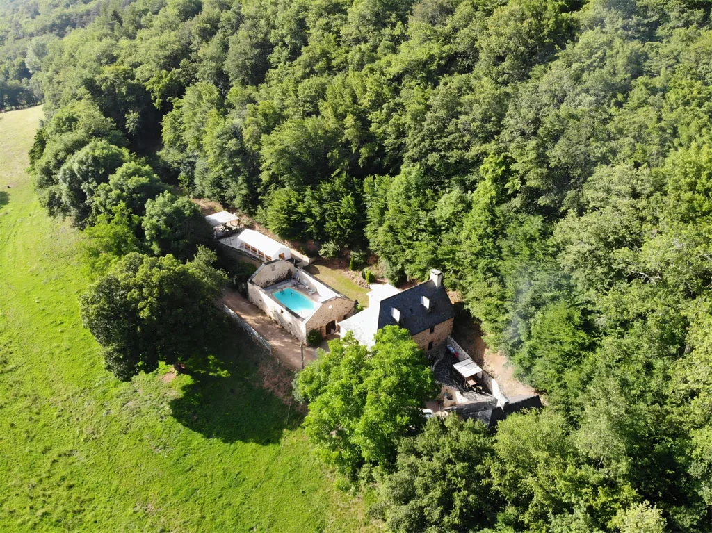 Vue aérienne du domaine du Charlu, bâtisse et piscine entourées de 5 hectares boisés