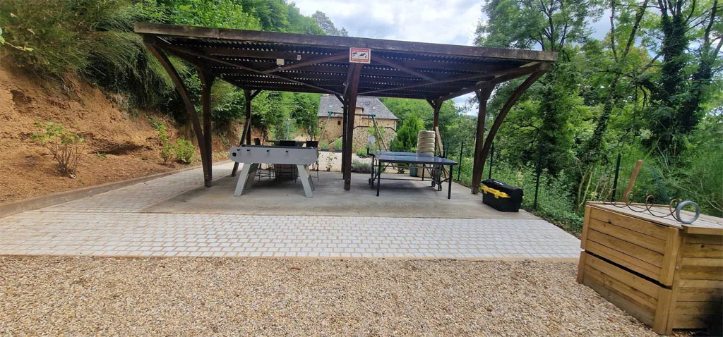 Terrasse couverte par une pergola bioclimatique avec grande table de repas extérieure