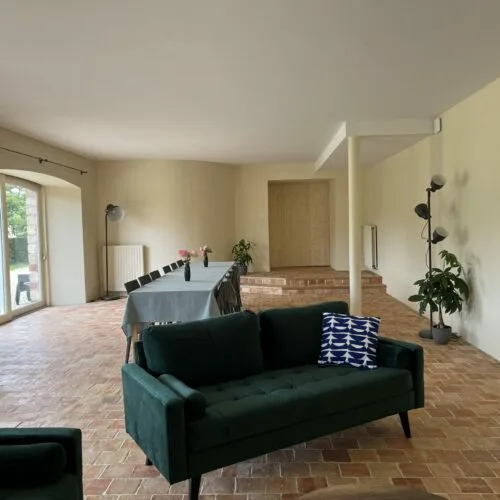 Grand salon-salle à manger avec table dressée pour un groupe