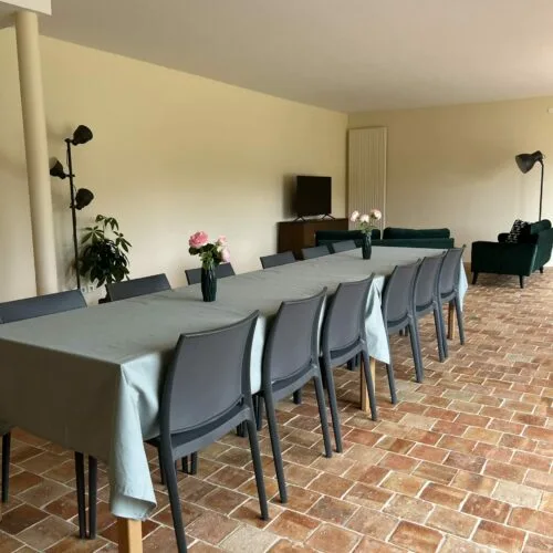Salle à manger avec longue tablée et chaises pour recevoir un groupe