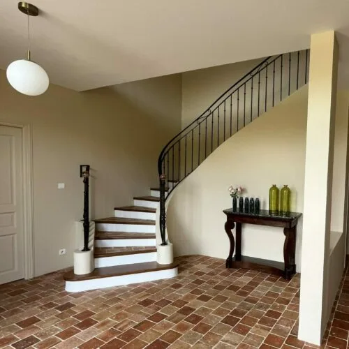 Escalier en pierre et fer forgé dans le hall d'entrée