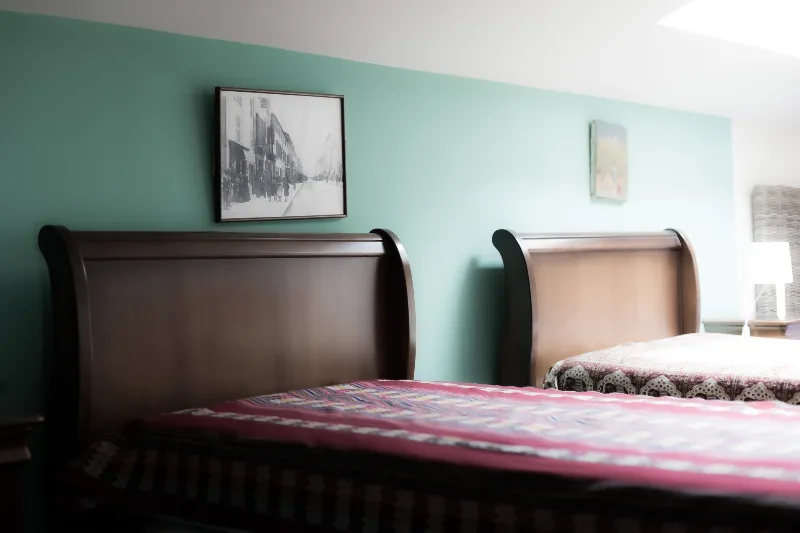 Chambre avec lits jumeaux et mur vert menthe