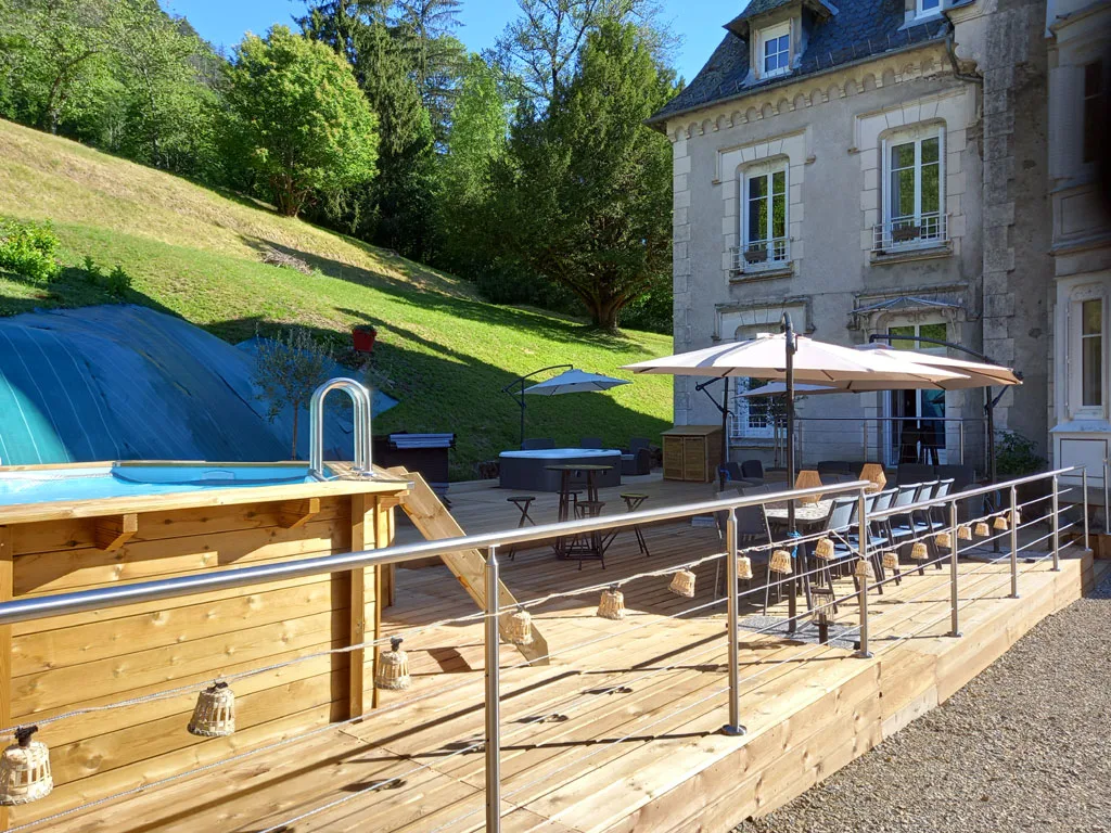 Terrasse avec piscine hors sol en bois et vue dégagée sur les montagnes du Cantal