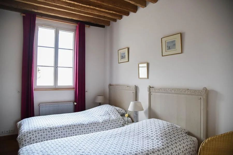 Chambre avec deux lits jumeaux et poutres au plafond