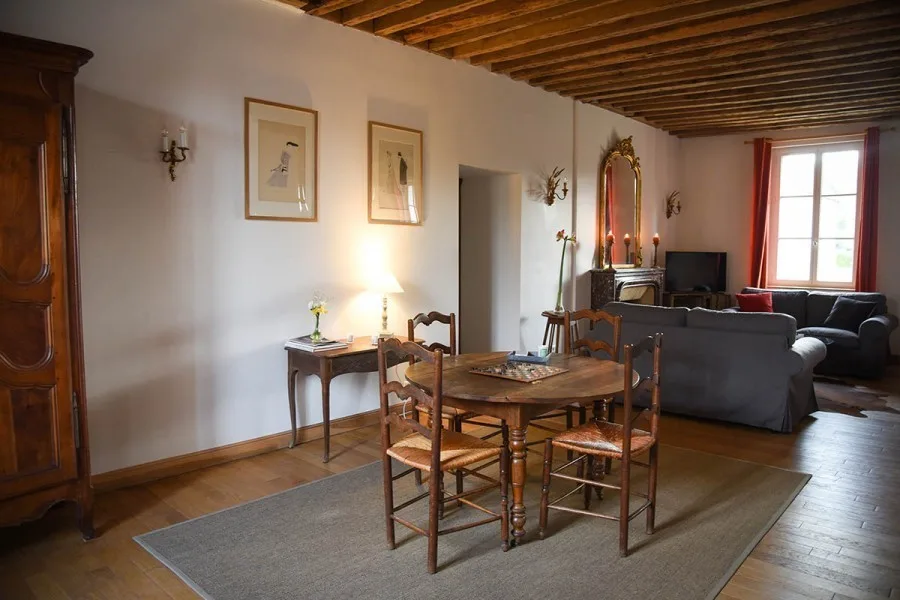 Salon avec cheminée en marbre, grand miroir doré et canapés confortables