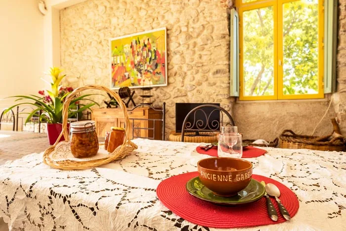 Salle à manger lumineuse avec grande table en fer forgé et fenêtre cintrée