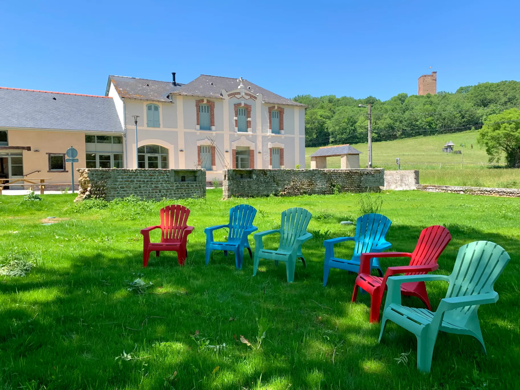 Gîte de groupe Lo Castet de Fébus à Montaner — Façade de l'ancien presbytère rénové avec vue sur la tour du château de Montaner, capacité 29 personnes