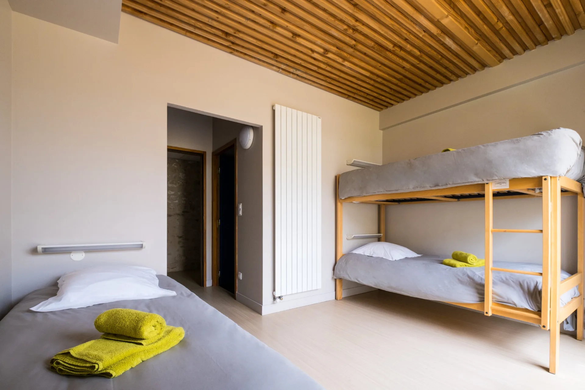 Chambre avec trois lits simples aux couleurs vives