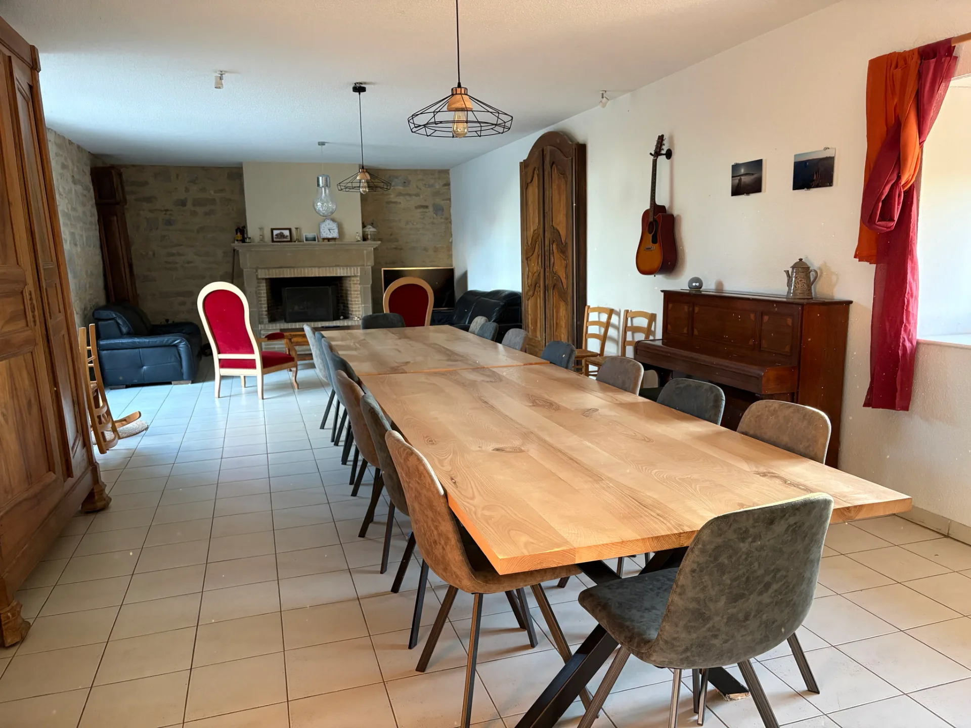 Grande salle de séjour de 70 m² avec tables et coin salon