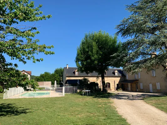 Façade en pierre avec piscine, grand jardin arboré et allée d'accès