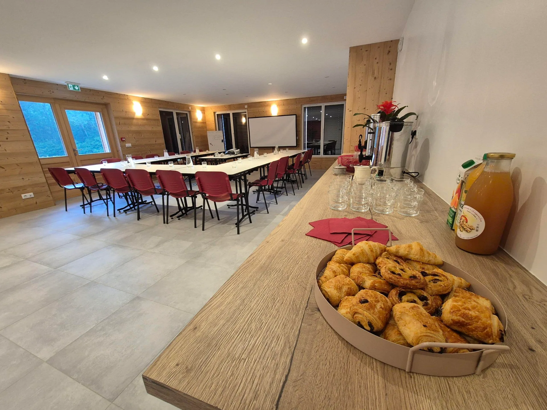 Grande salle à manger et cuisine ouverte avec longue table dressée pour 15 convives