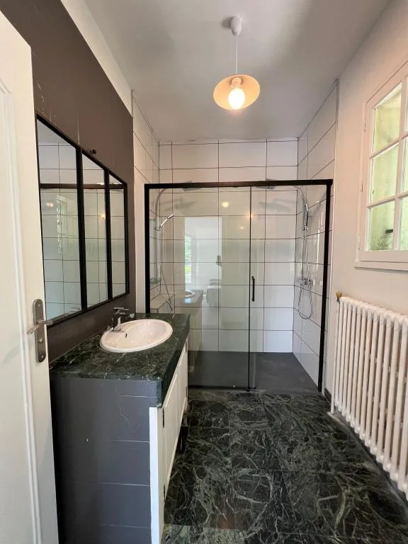 Salle de bain avec douche à l'italienne vitrée et vasque sur meuble marbre vert