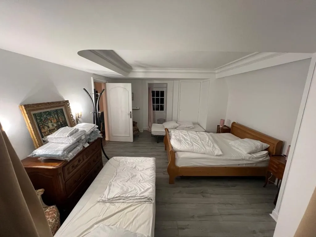 Chambre spacieuse avec deux lits en bois et commode ancienne