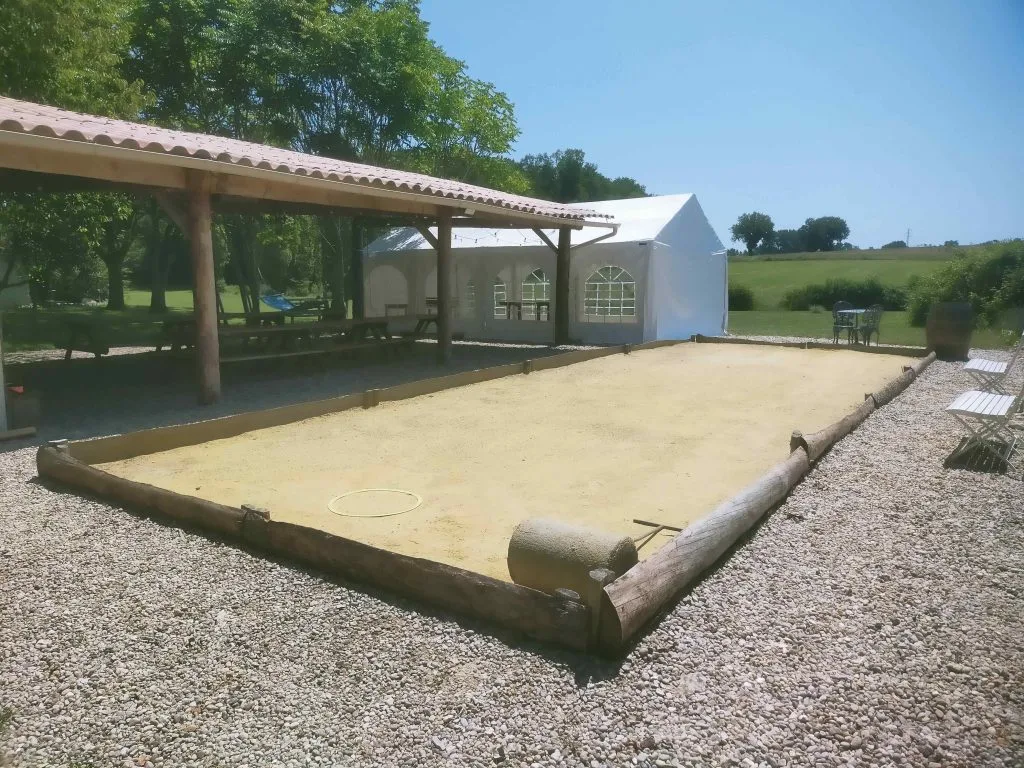 Espace guinguette couverte avec tables en bois pour les repas de groupe