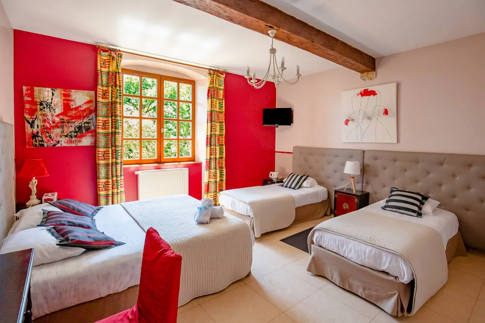 Chambre cosy aux tons rouges avec lits et ambiance chaleureuse