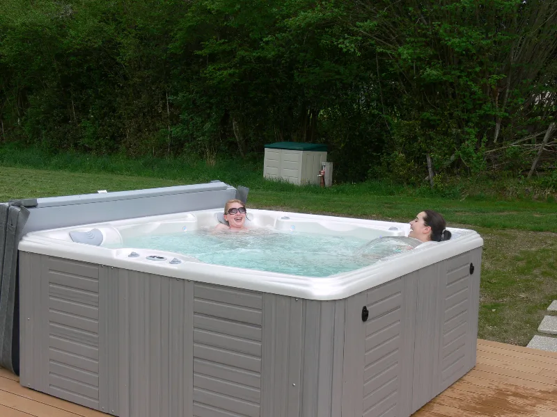 Jacuzzi extérieur installé dans le jardin, espace bien-être du domaine