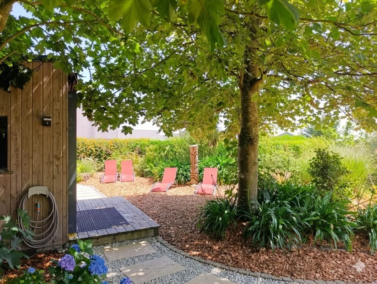 Espace extérieur ombragé avec transats et hortensias fleuris