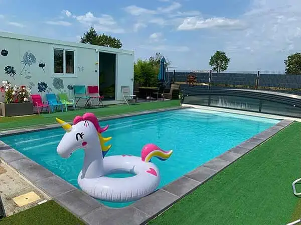 Espace piscine privé en extérieur avec pool-house équipé, transats et coin repas