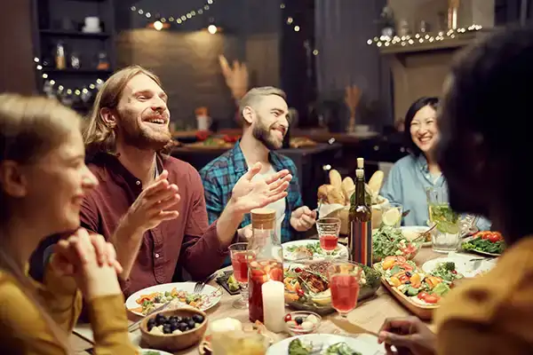 Repas convivial en terrasse entre amis autour d'une grande table