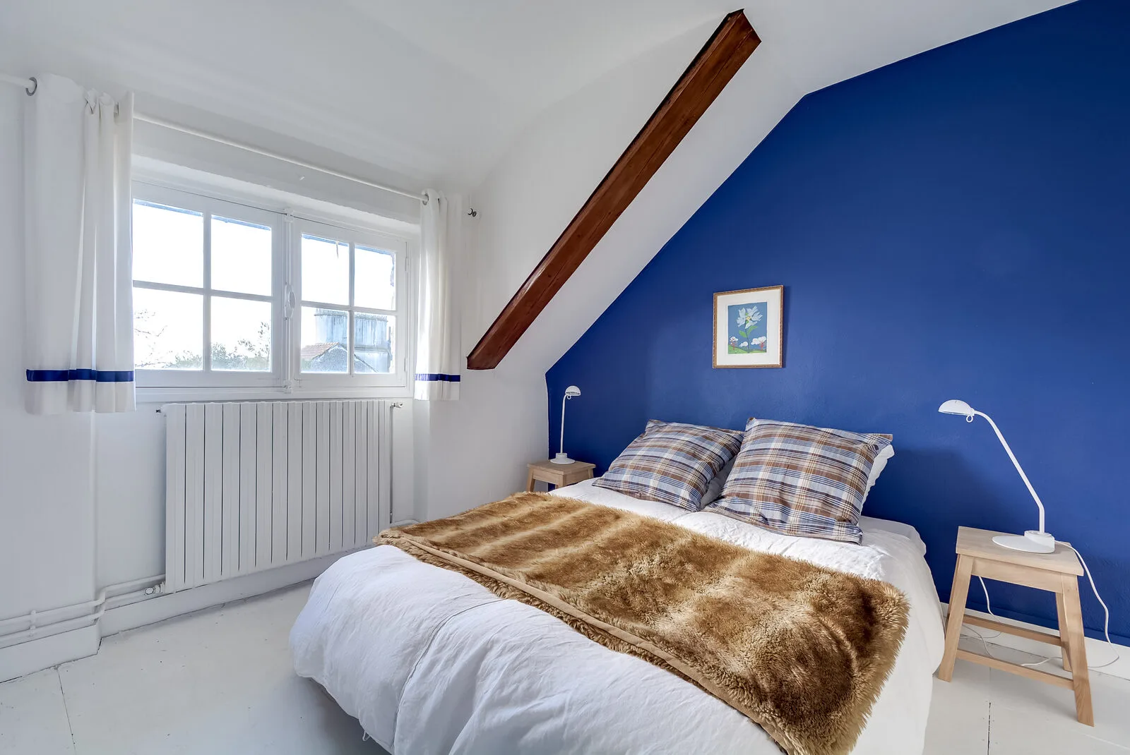 Chambre lumineuse avec lits et décoration simple