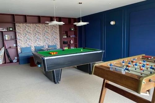 Salle de jeux avec billard et espace détente pour tous les âges
