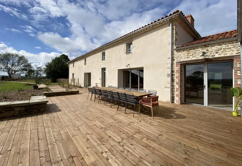 Grande terrasse extérieure avec table conviviale pour un repas en groupe