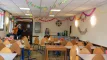 Grande salle à manger commune avec longues tables en bois pour les repas de groupe