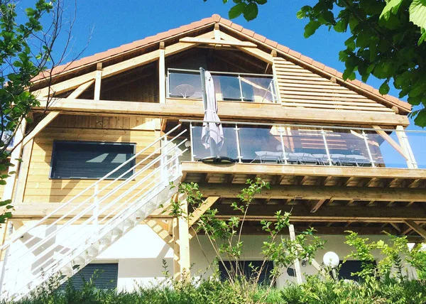 Façade en bois du Chalet Lucy avec grand balcon, terrasse et escalier extérieur