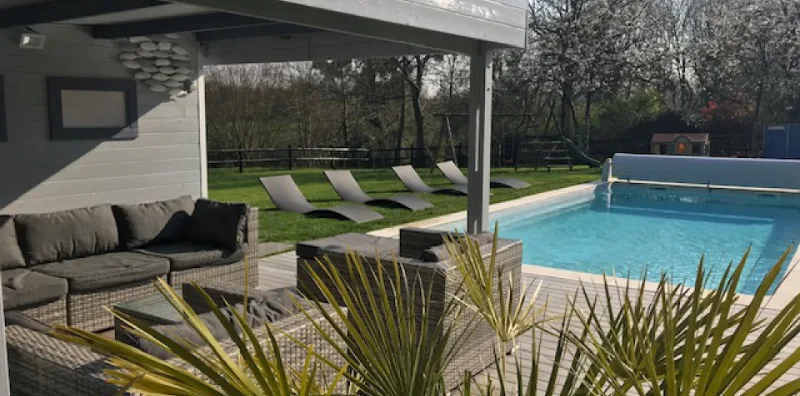Piscine chauffée avec terrasse couverte, salon extérieur et transats