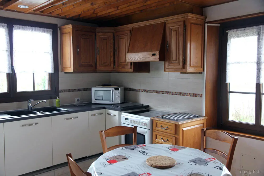 Cuisine équipée avec plan de travail et rangements en bois clair