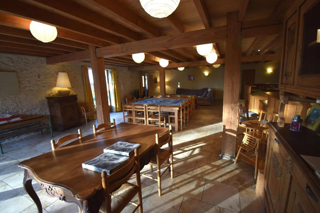 Grande salle à manger avec longues tables en bois pour les repas de groupe
