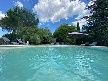 Piscine du mas vue depuis la terrasse avec transats et espace détente