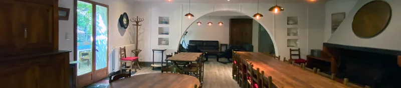 Grand salon-salle à manger avec longue table en bois pour les repas de groupe