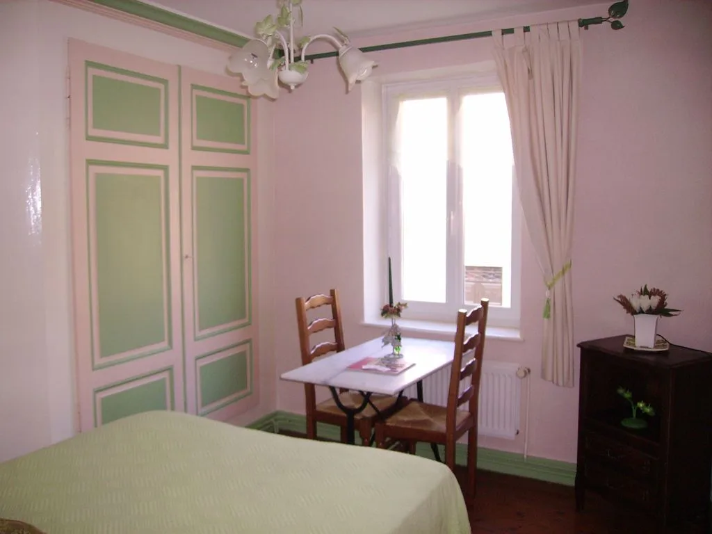 Chambre Émeraude avec armoire peinte, petite table et lit double