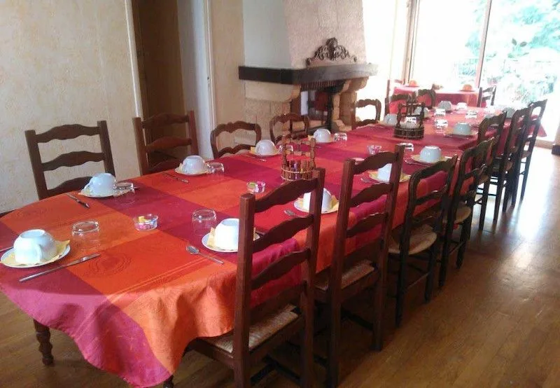 Longue table dressée pour le petit-déjeuner en commun avec nappe colorée