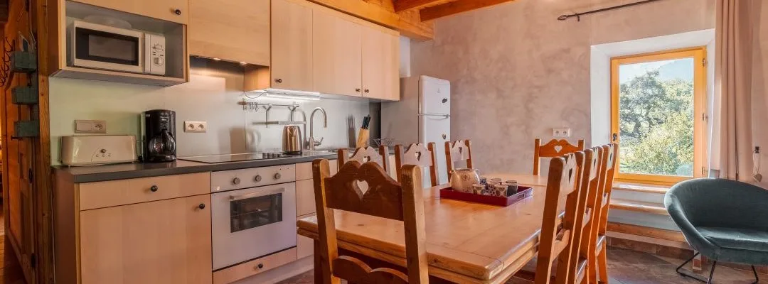 Cuisine équipée du gîte Rochette avec plaques de cuisson et rangements en bois clair
