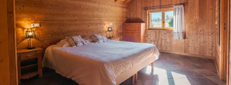 Chambre du gîte Rochette avec deux lits et fenêtre donnant sur la campagne
